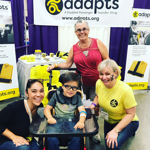 A young boy and his family pose at the ADAPTS booth